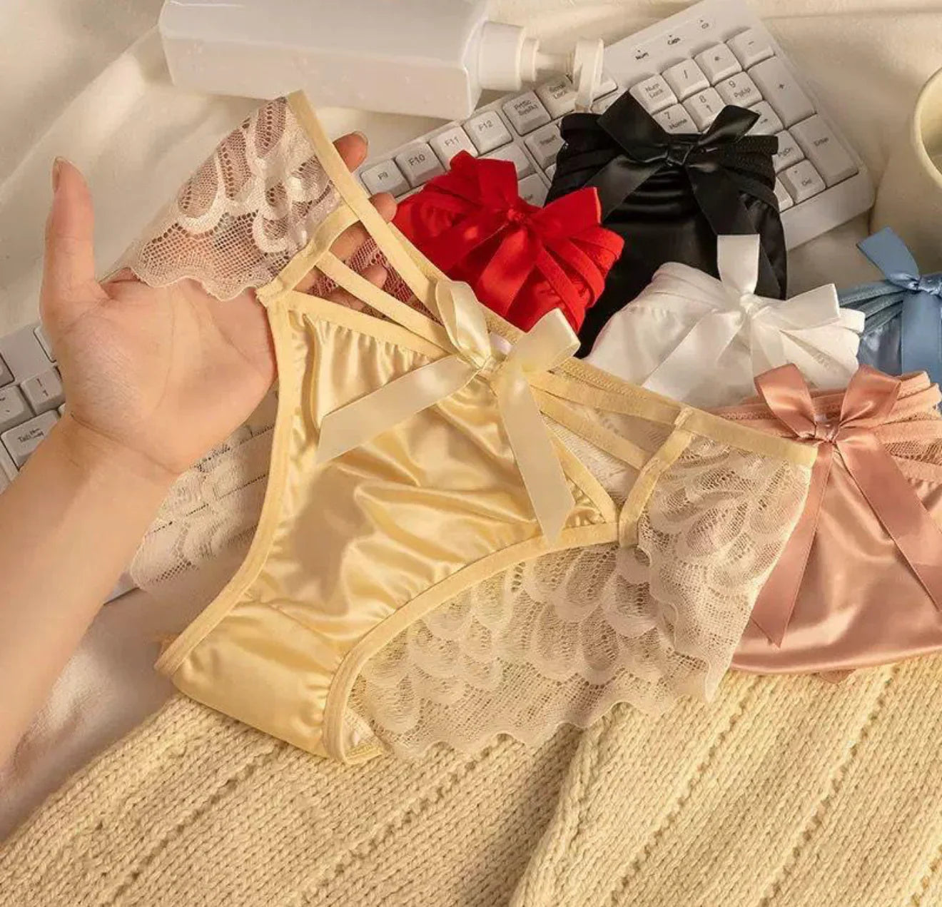 Assorted women’s lace and satin panties with bows, showcasing elegant, comfortable lingerie.