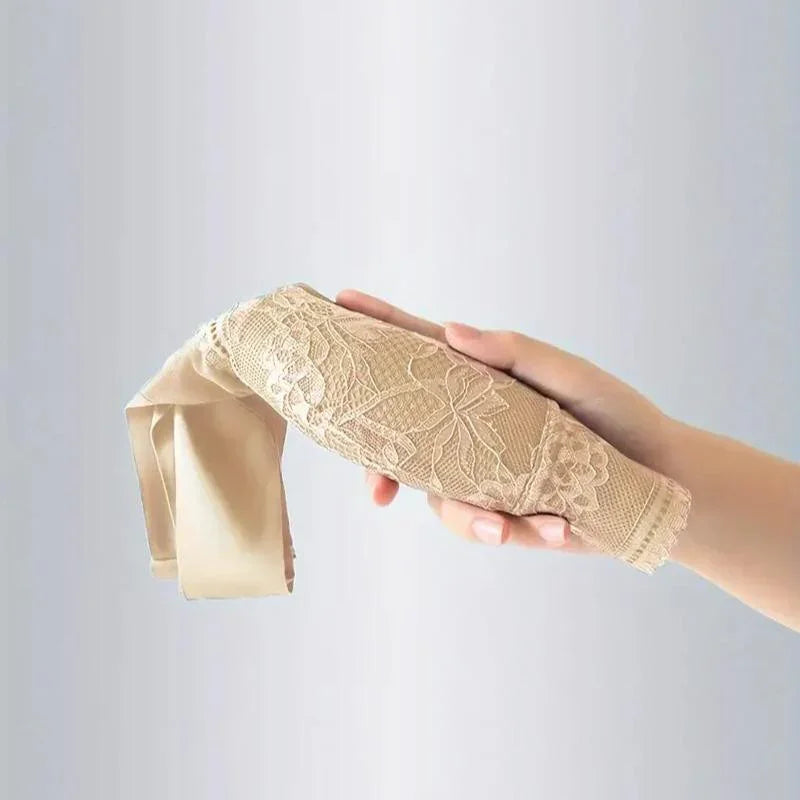 Hand holding a beige lace women’s undergarment, soft fabric and elegant floral pattern